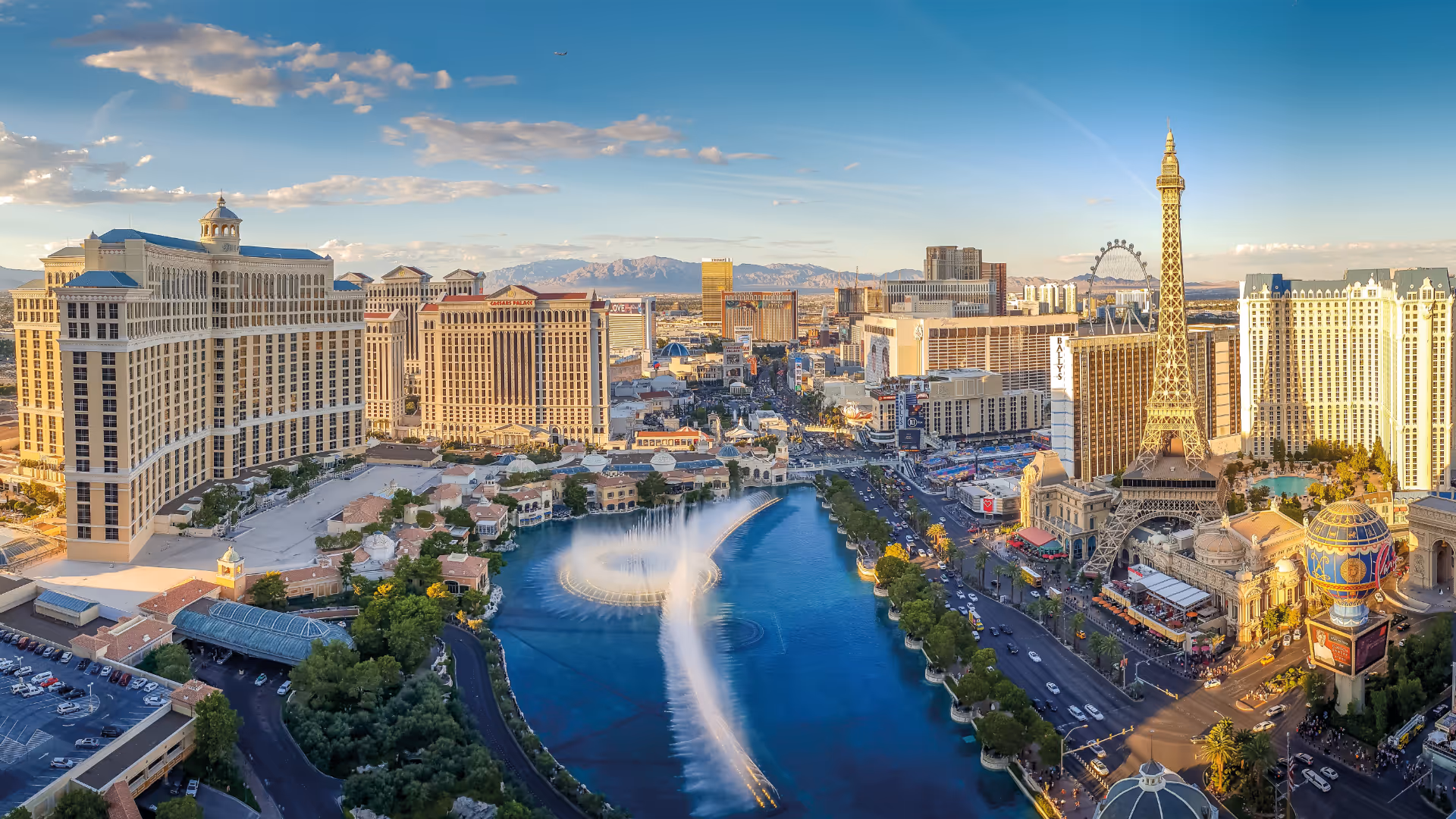 The Las Vegas Strip from the air at golden hour, the Bellagio fountains mid-display.